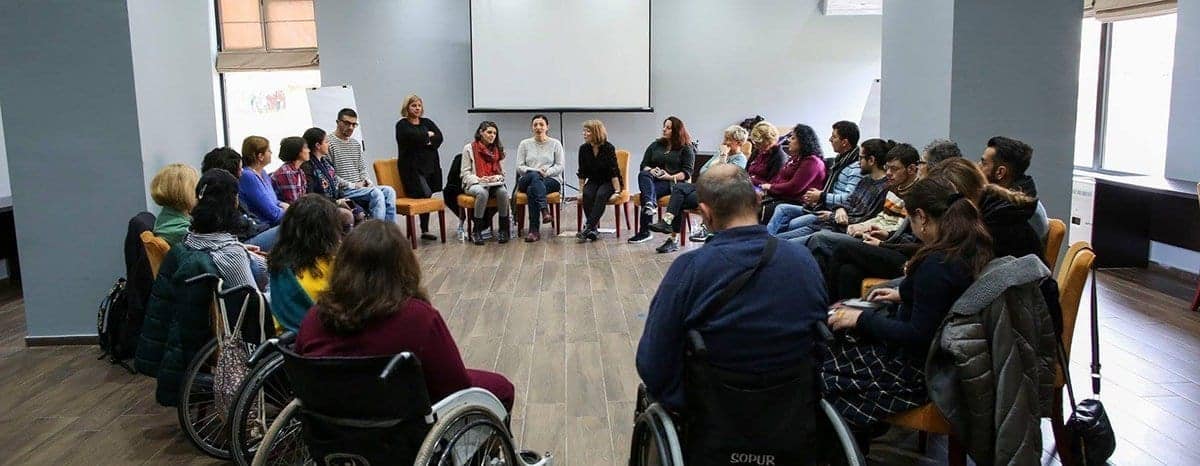 A group engaged in storytelling seated in a room.