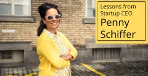 Startup CEO Penny Schiffer in a yellow sweater and sunglasses smiling at the camera