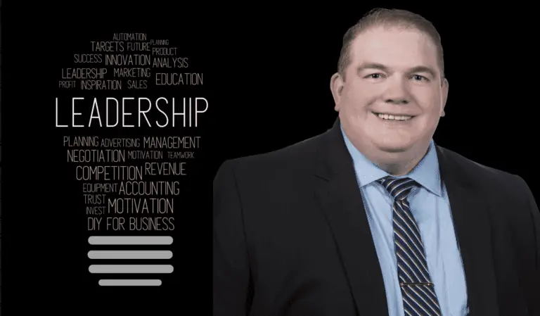 A leadership figure in a suit and tie against a black background.