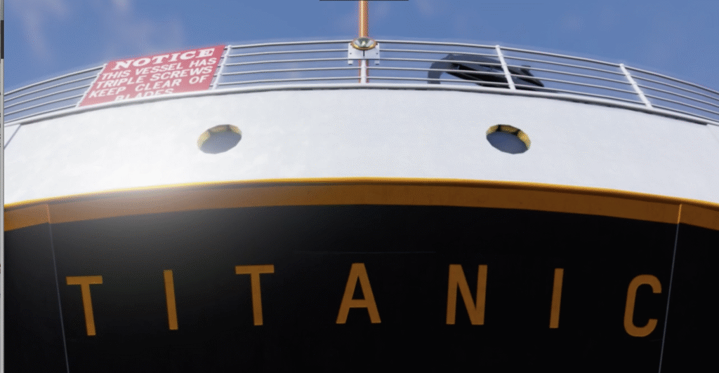 Close-up view of the Titanic's bow, showing the ship's name and a red warning sign about the vessel's triple screws, with part of the deck and railing visible.
