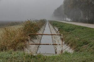 a flooded road with a gate in the middle of it