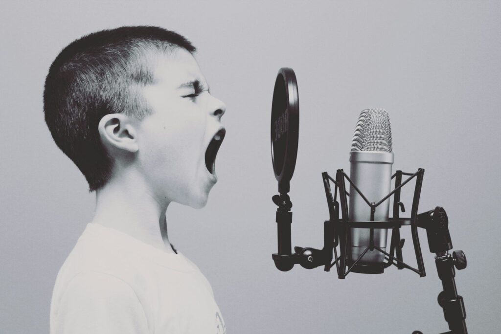 boy singing on microphone with pop filter