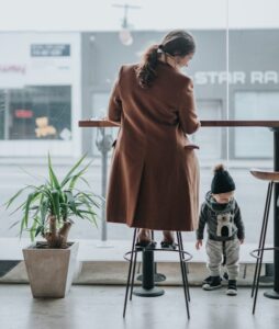person sitting in stool looking at toddler