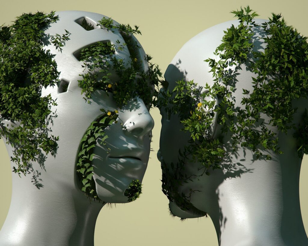 Seeing People, Not Profiles 2 A 3D render of two white mannequin heads covered in green vines and small yellow flowers